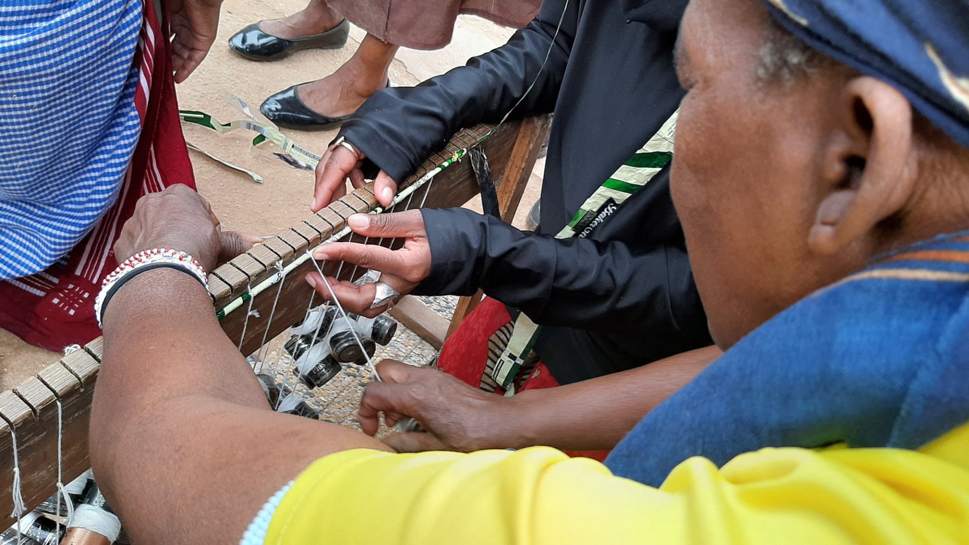 Hands working a wooden loom